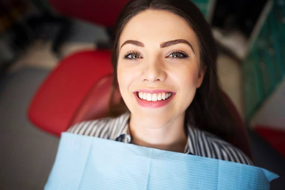 woman smiles in a dental chair